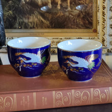 Load image into Gallery viewer, Hand Painted Cobalt Blue Porcelain Teacups with Crane in Flight and Gold Gilding - Set of 2