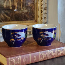 Load image into Gallery viewer, Hand Painted Cobalt Blue Porcelain Teacups with Crane in Flight and Gold Gilding - Set of 2