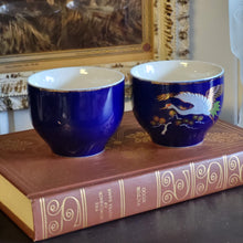 Load image into Gallery viewer, Hand Painted Cobalt Blue Porcelain Teacups with Crane in Flight and Gold Gilding - Set of 2