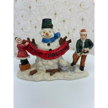 Load image into Gallery viewer, Snowman Figurine - Children Building a Snowman Holding a Merry Christmas Banner