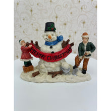 Load image into Gallery viewer, Snowman Figurine - Children Building a Snowman Holding a Merry Christmas Banner